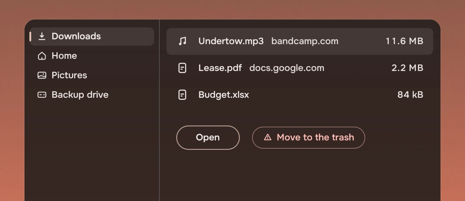 A window on the wallpaper with a rail whose Downloads row is current, three file rows, the first selected, and two buttons: Open, with a ring in the accent, and Move to the trash in the risk ink.