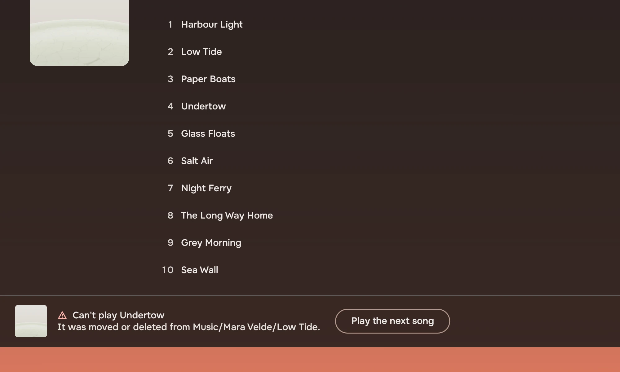 An album's song list in which the fourth row, Undertow, has a warning symbol instead of its number. The player bar below says Can't play Undertow, It was moved or deleted from Music/Mara Velde/Low Tide, with a button, Play the next song.