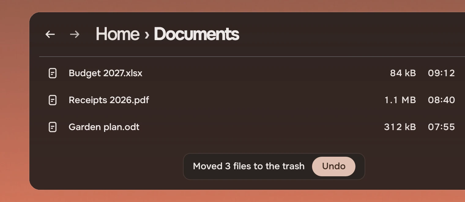 Part of a Files window headed Home, Documents, with three files. At the window's foot sits a line, Moved 3 files to Documents, with an accent button, Undo.