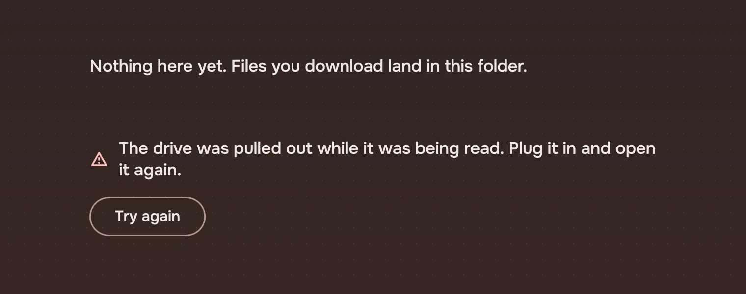 An empty page: Nothing here yet. Files you download land in this folder. And a failed one with the warning symbol: The drive was pulled out while it was being read. Plug it in and open it again, with a Try again button.